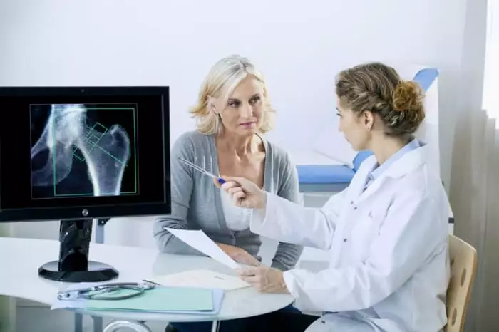 Médico mostrando na tela do computador um rx de articulação coxofemural