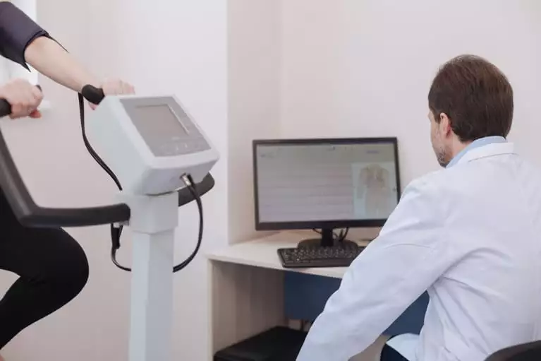 Médico realizando uma ergometria em bicicleta