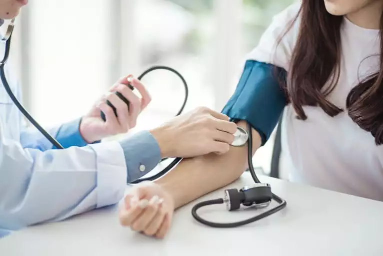 Médico mede a pressão arterial no consultório