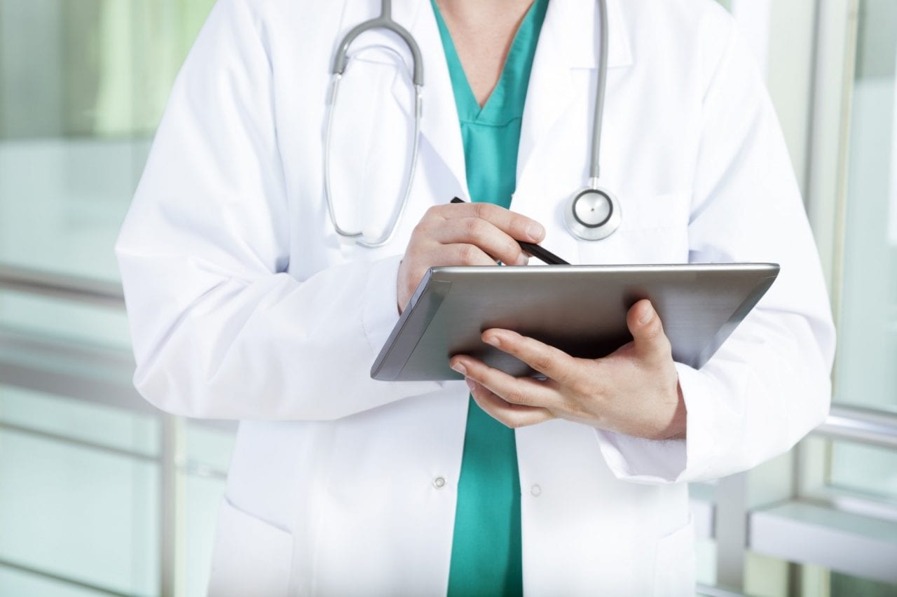 Médico segurando um tablet com bulário online